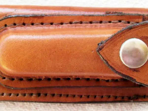 Small leather accessory with metal fastener
