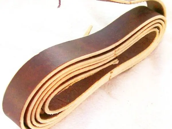 Rolled brown leather belt on display