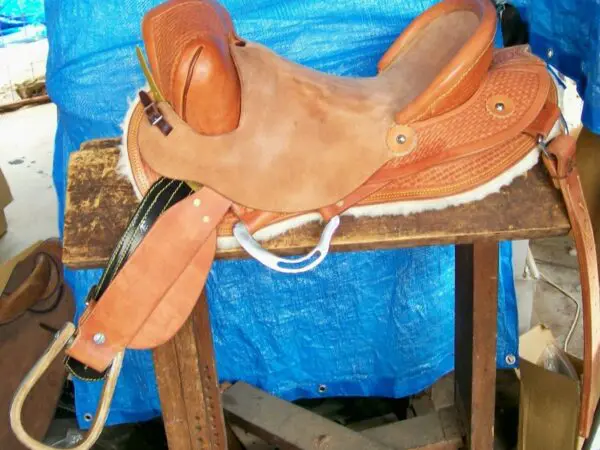 Western saddle with blue tarp background