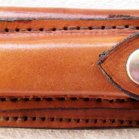 Small leather accessory with metal fastener