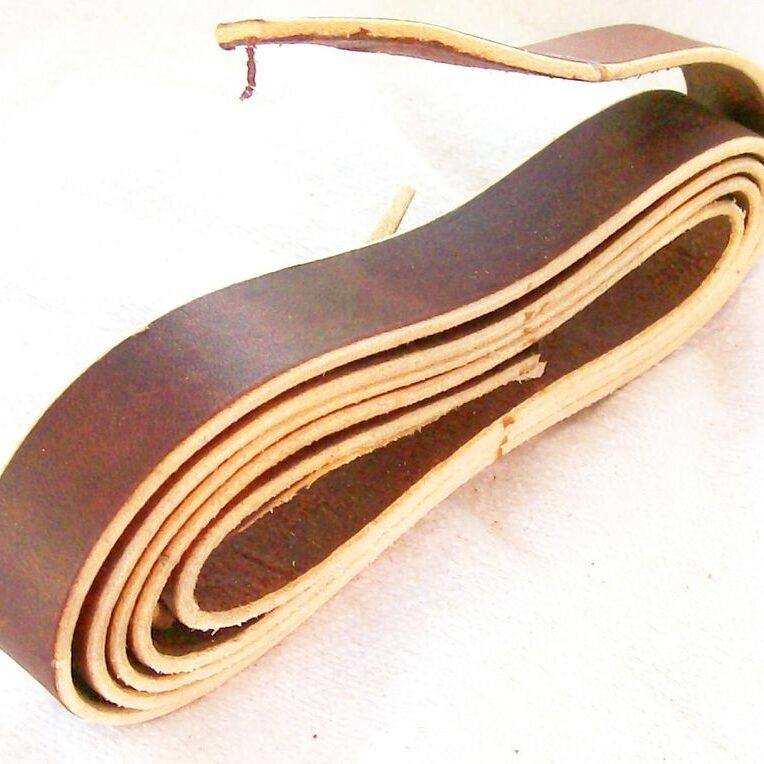 Rolled brown leather belt on display