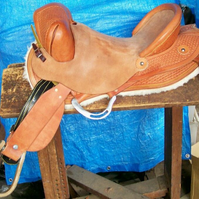 Western saddle with blue tarp background